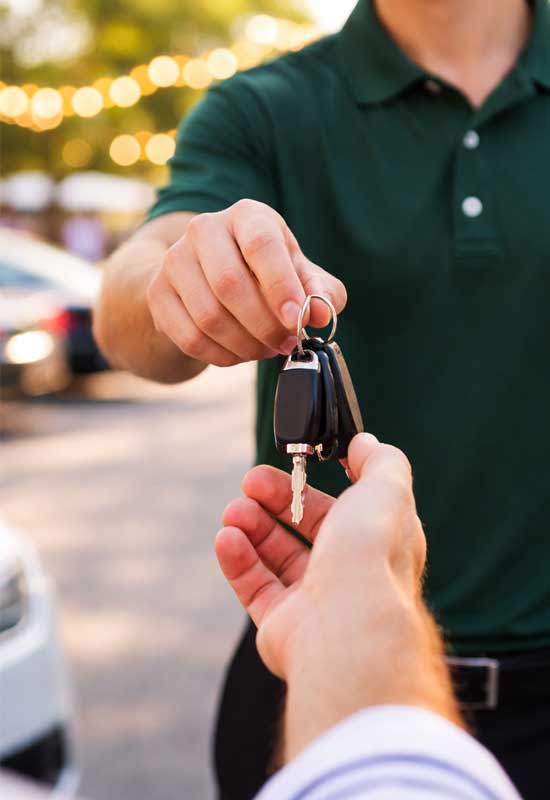 Valet attendant in Des Moines Iowa receiving car keys from guest at event parking service